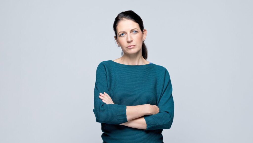 „Frau mit verschränkten Armen – Körpersprache der Abwehr als Symbol für fehlende Einsicht in der MPU"